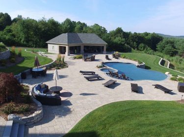 A large patio surrounding an in-ground pool