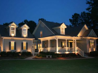 A home exterior at night illuminated with outdoor lighting