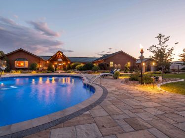 An in-ground pool surrounded by a patio at dawn